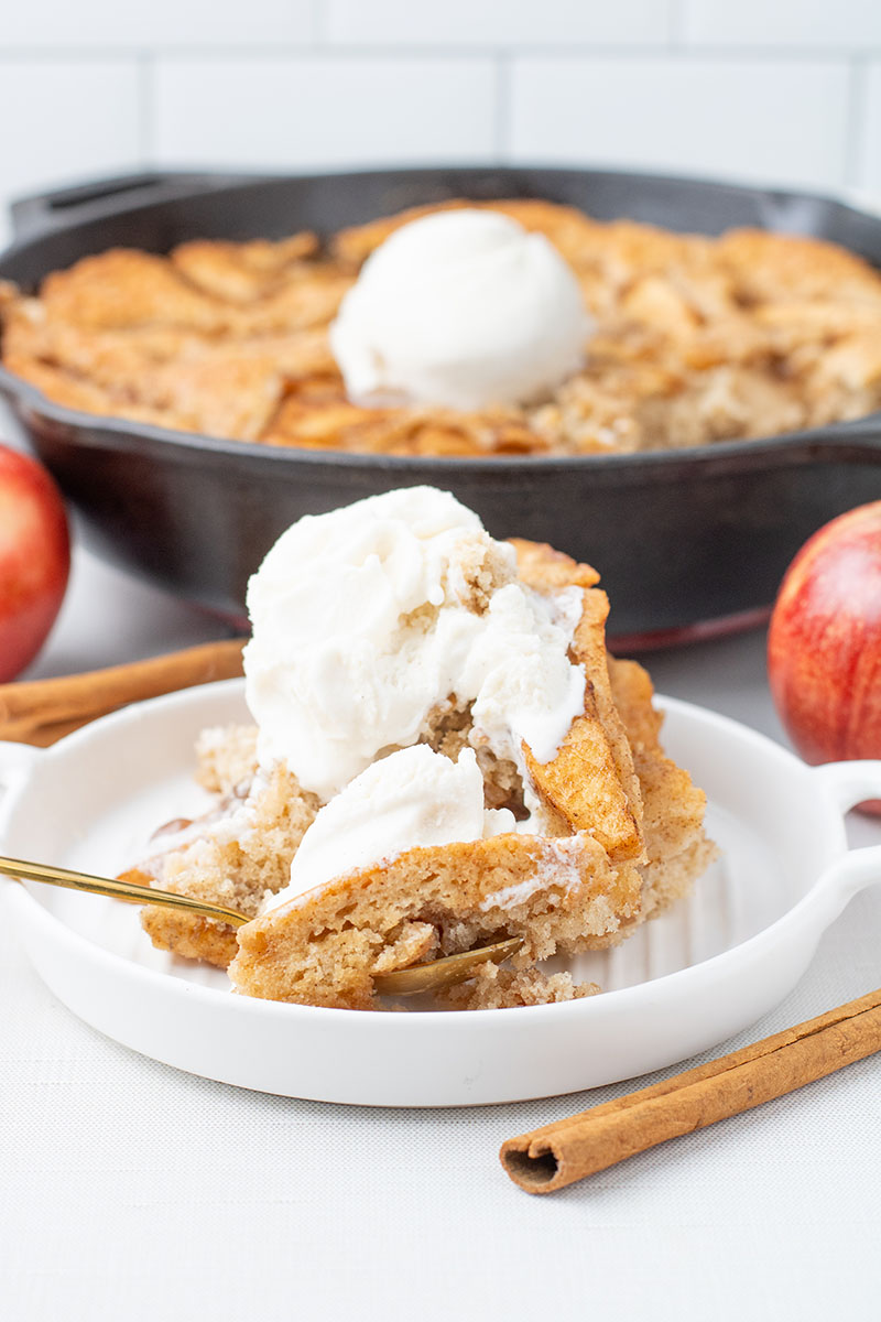 delicious apple pie cobbler recipe in a cast iron pan with the cobbler on a plate