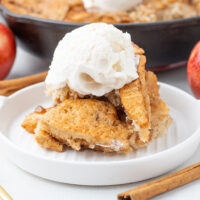 delicious apple pie cobbler recipe in a cast iron pan with the cobbler on a plate