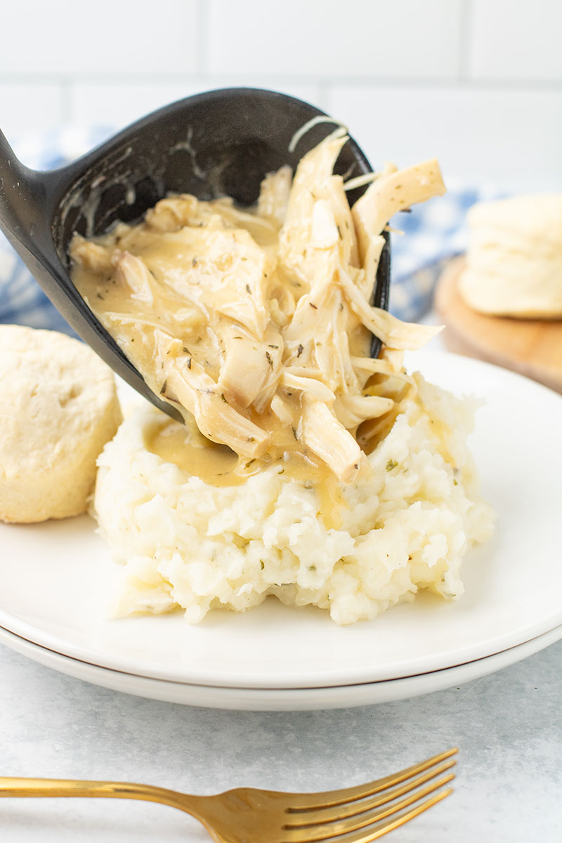 dish of Crockpot Chicken and Gravy on a plate with vegetables