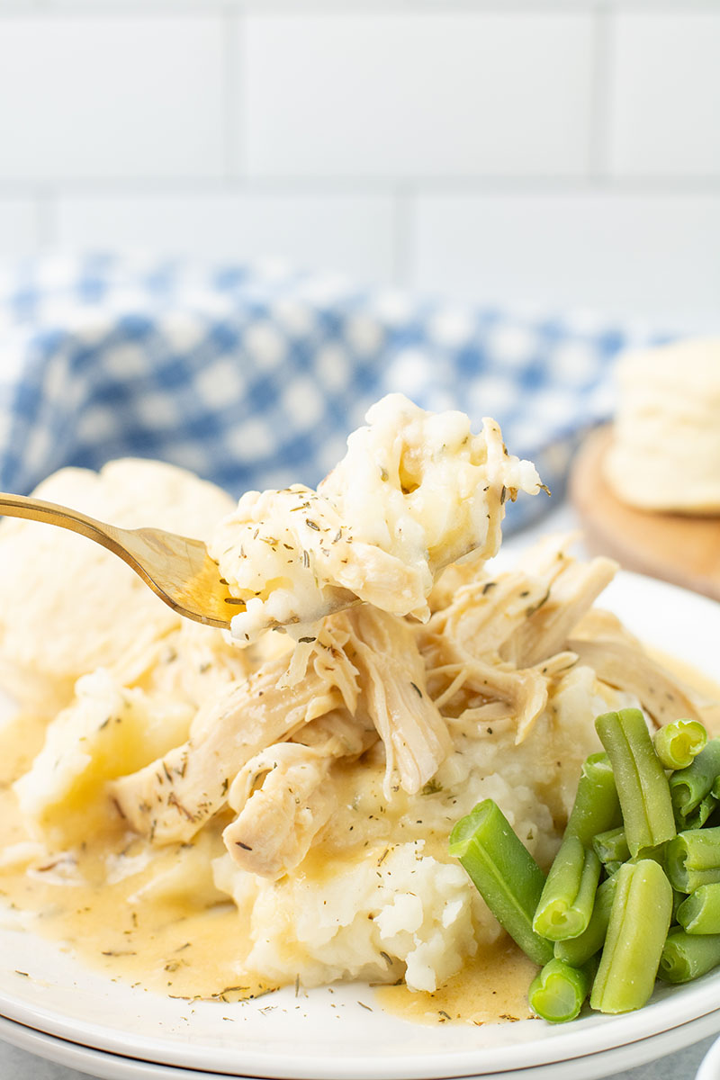 dish of Crockpot Chicken and Gravy on a plate with vegetables