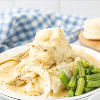 dish of Crockpot Chicken and Gravy on a plate with vegetables